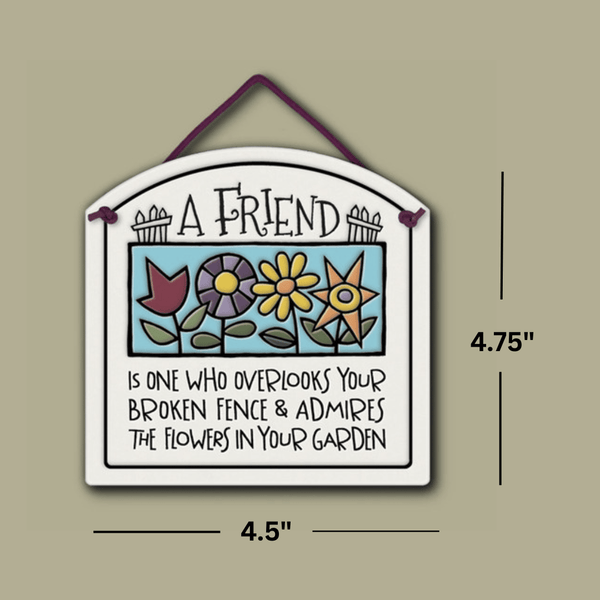 Ceramic wall tile with colorful flowers and the quote ‘A friend is one who overlooks your broken fence and admires the flowers in your garden,’ shown with dimensions 4.75 inches tall and 4.5 inches wide.