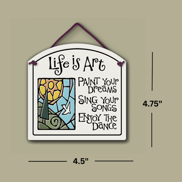 Ceramic wall tile with colorful sun and landscape illustration and the quote ‘Life is art—paint your dreams, sing your songs, enjoy the dance,’ shown with dimensions 4.75 inches tall and 4.5 inches wide.