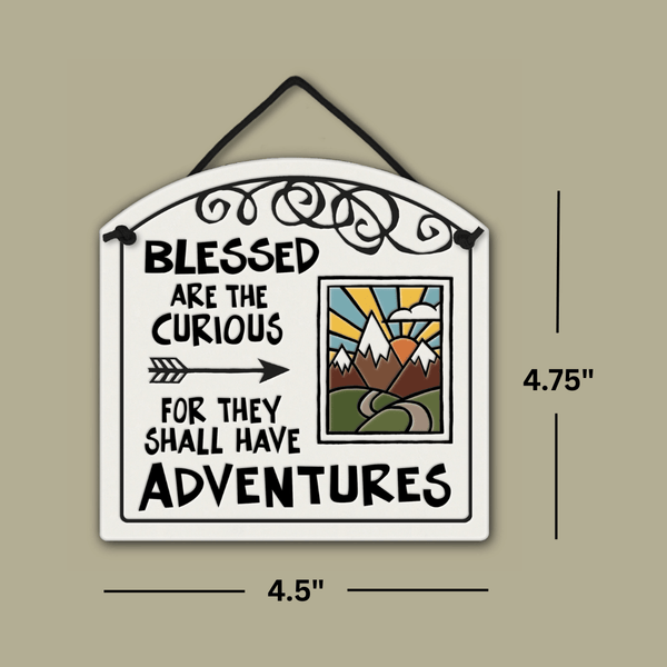 Ceramic wall tile with the quote ‘Blessed are the curious for they shall have adventures,’ shown with dimensions 4.75 inches tall and 4.5 inches wide.