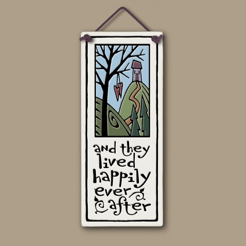 Spooner Creek large tall ceramic tile with the quote “and they lived happily ever after,” featuring a whimsical cottage on a hill, hanging hearts, and pastel nature artwork; handcrafted wall décor measuring 3.5 x 8.5 inches.