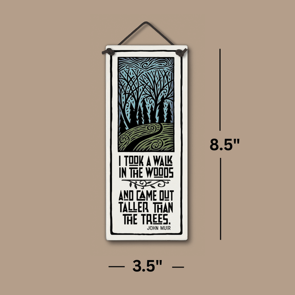 Spooner Creek ceramic tall tile, 3.5 x 8.5 inches, featuring John Muir’s I took a walk in the woods and came out taller than the trees design, shown with measurement lines on tan background.