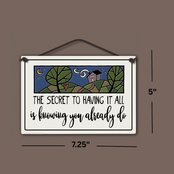 Spooner Creek large rectangle ceramic tile with quote “The secret to having it all is knowing you already do,” night sky and house artwork, black text, shown with dimensions 7.25 x 5 inches.