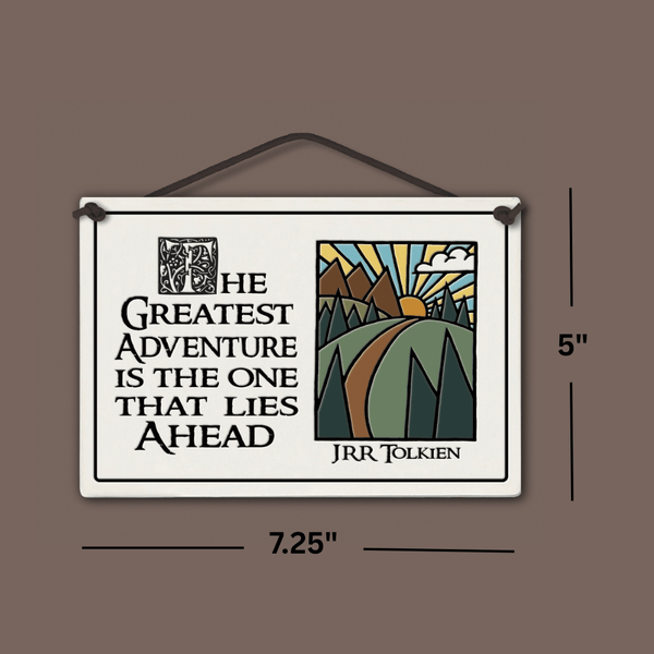Spooner Creek large rectangle ceramic tile wall hanging with quote “The greatest adventure is the one that lies ahead – JRR Tolkien,” mountain sunrise and winding path artwork, black lettering, dimensions shown 7.25 x 5 inches.