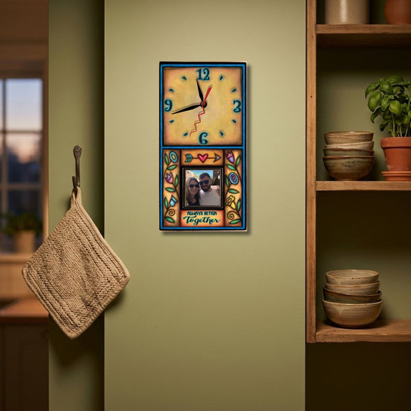 Always Better Together picture frame wood wall clock hanging above a dusty blue velvet headboard on a soft clay pink bedroom wall