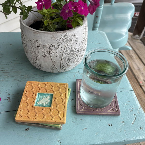 Handmade golden yellow ceramic bee coaster with crazed glass center styled with a mug on a matching ceramic coaster by Macone Clay.