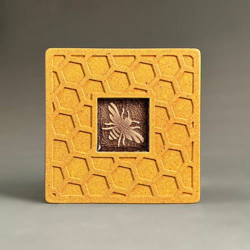 Handmade golden yellow ceramic bee coaster with crazed glass center and carved honeycomb border by Macone Clay