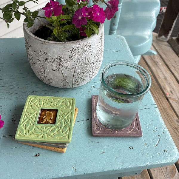 Handmade turquoise ceramic Bigfoot coaster with crazed glass center styled with a mug on a matching ceramic coaster by Macone Clay