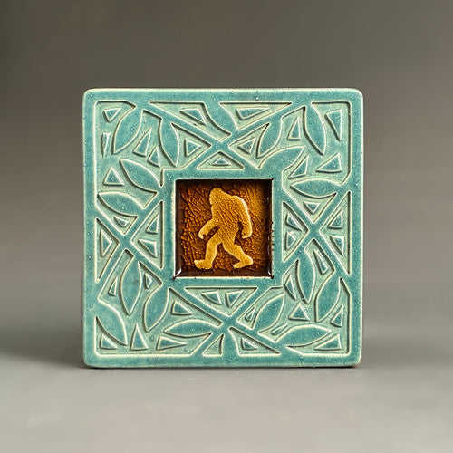 Handmade turquoise ceramic Bigfoot coaster with crazed glass center and carved vine border by Macone Clay