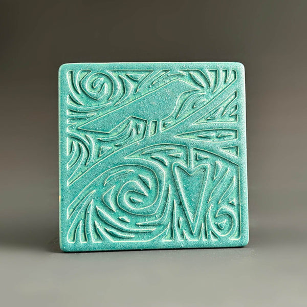 Handmade turquoise ceramic bird and heart coaster with swirling carved detail by Macone Clay