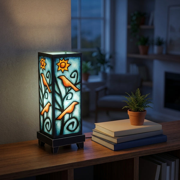 Birds in Tree mood lamp glowing on a living room shelf