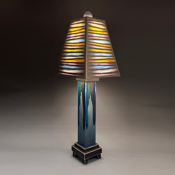Bright Stripes handmade ceramic table lamp with straight blue extruded clay base, glowing multicolor striped shade by Michael Macone, made in Shell Lake Wisconsin