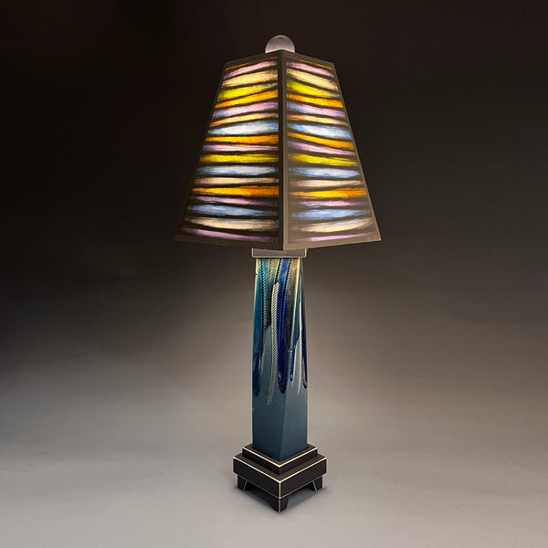  Bright Stripes handmade ceramic table lamp with twisted blue extruded clay base, glowing striped multicolor shade by Michael Macone, made in Shell Lake Wisconsin