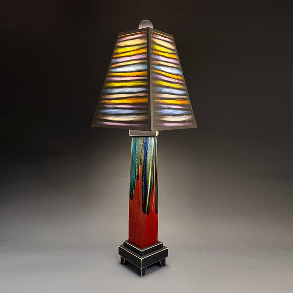 Bright Stripes handmade ceramic table lamp with twisted red extruded clay base, glowing yellow orange and blue striped shade by Michael Macone, made in Shell Lake Wisconsin