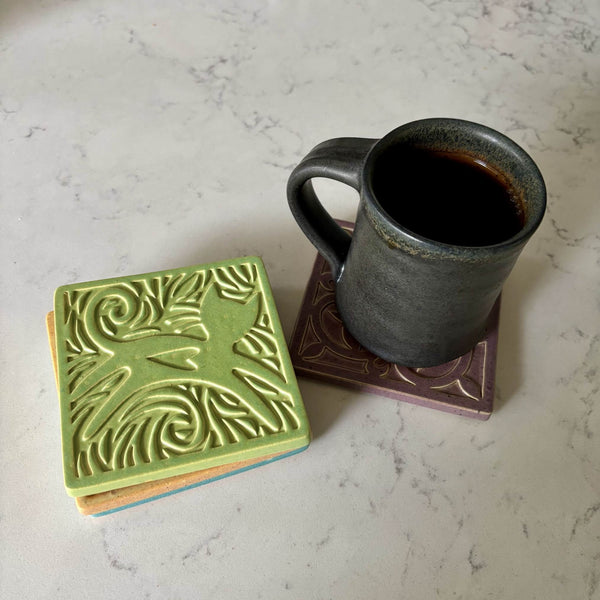 Handmade lime green ceramic cat coaster styled with a mug on a matching ceramic coaster by Macone Clay