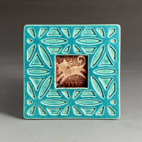 Handmade turquoise ceramic cat coaster with crazed glass center and carved geometric border by Macone Clay