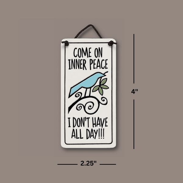 Dimensions image of Spooner Creek Mini Charmer ceramic tile measuring 2.25 x 4 inches, featuring a witty inner peace quote and leather like cord ready for hanging.