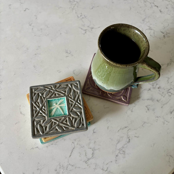Handmade ceramic dragonfly coaster with crazed glass center styled with a mug on a matching ceramic coaster by Macone Clay