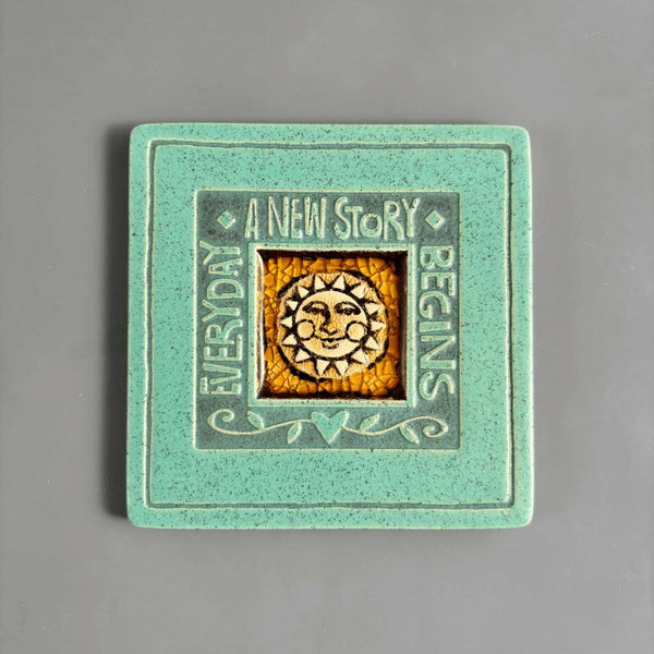 Handmade turquoise ceramic Everyday a New Story Begins coaster with smiling sun and crazed glass center by Macone Clay.