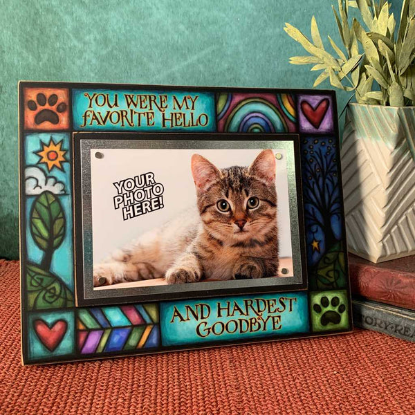 Pet memorial picture frame with the quote You were my favorite hello and hardest goodbye displayed on shelf with colorful artwork and 4x6 photo.