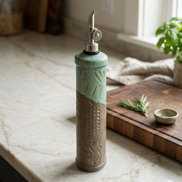 Gray handmade stoneware olive oil cruet on kitchen counter with pour spout, ceramic oil dispenser by Macone Clay, functional and decorative kitchen accessory