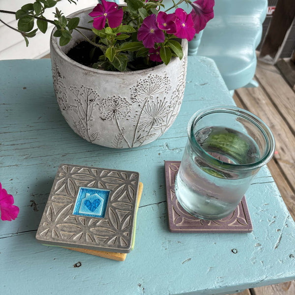 Handmade gray ceramic house with heart coaster with crazed glass center styled with a mug on a matching ceramic coaster by Macone Clay.