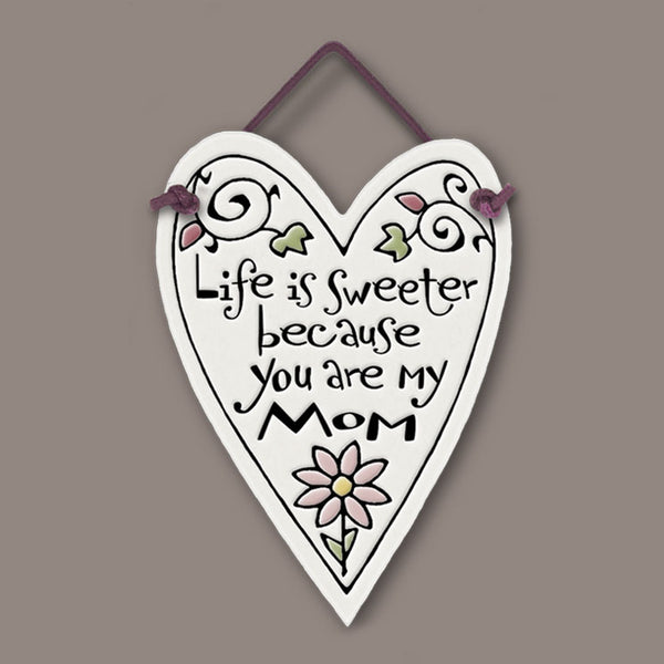 Heart shaped Spooner Creek mini charmer with the quote “Life is sweeter because you are my mom,” handmade ceramic tile gift with floral design and hanging cord.