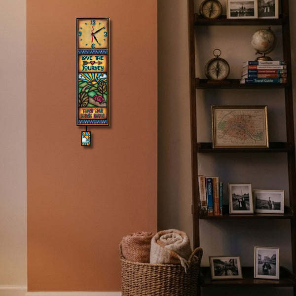 Love the Journey wood wall clock hanging on a living room wall near a window