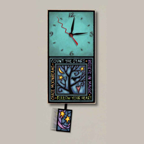 Follow Your Heart small wood wall clock by Michael Macone with a turquoise face, starry night tree artwork, and swinging star pendulum