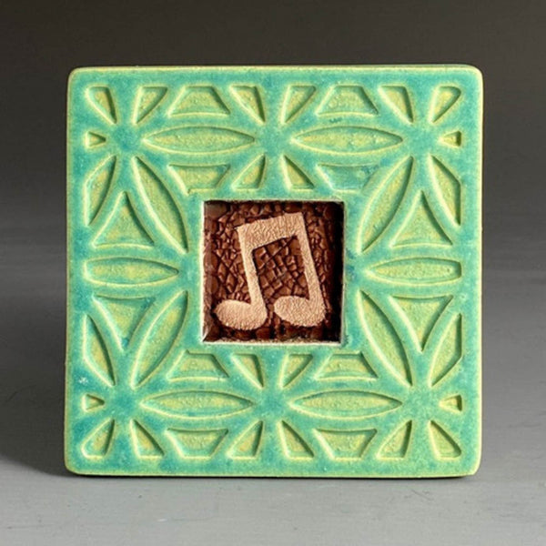 Handmade green ceramic music note coaster with crazed glass center and carved geometric floral border by Macone Clay