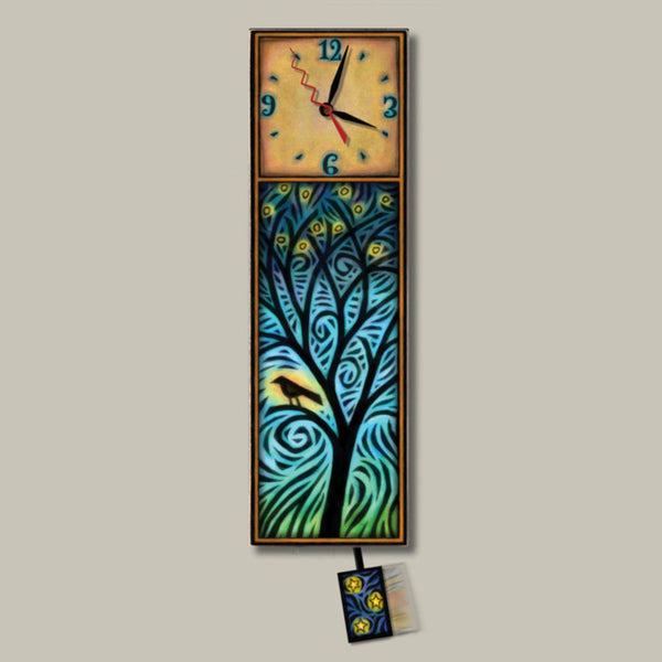 Night Bird Tree wood wall clock, a tall decorative wall clock with a square upper dial and a long rectangular lower panel featuring a stylized tree in swirling blue, teal, green, and yellow, with a small matching pendulum hanging below