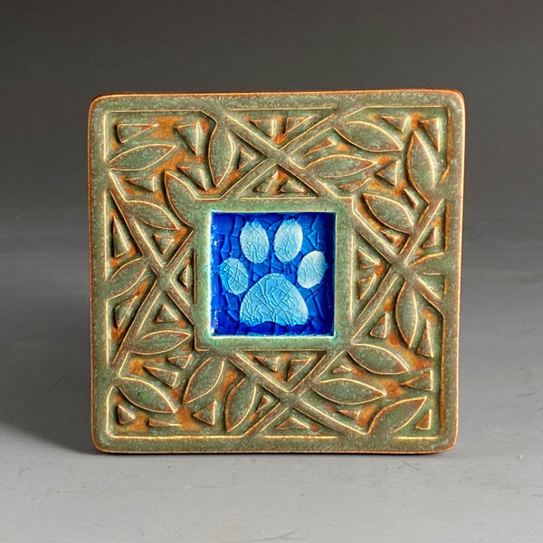 Handmade ceramic paw print coaster with crazed glass center and carved leaf border by Macone Clay