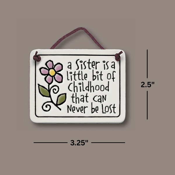 Dimensions image of Spooner Creek Mini Charmer ceramic tile measuring 2.25 by 4 inches, featuring a sentimental sister quote and leather like hanging cord.