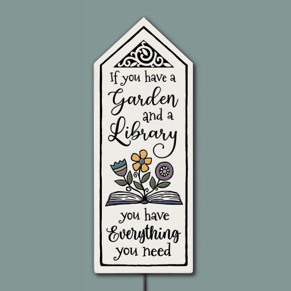 Hand-glazed ceramic garden tile stake with book and flower artwork featuring the quote “If you have a garden and a library, you have everything you need,” handmade outdoor garden decor by Spooner Creek.