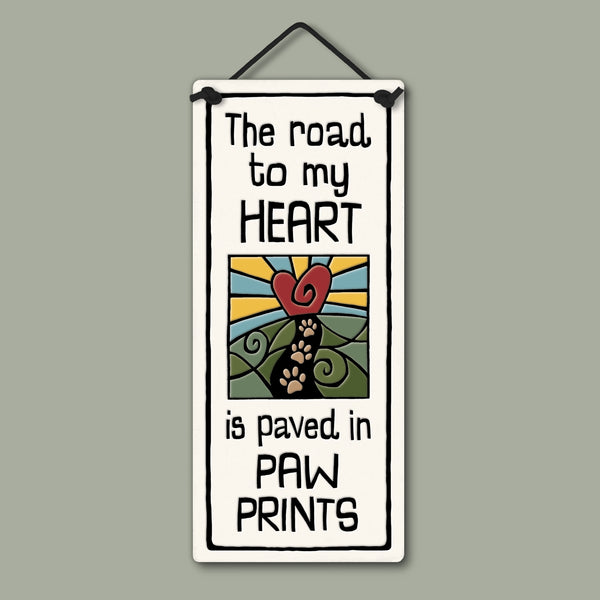 Handmade Spooner Creek small tall ceramic plaque with the quote “The road to my heart is paved in paw prints,” featuring a heart and paw print path design, ready-to-hang wall decor made in the USA