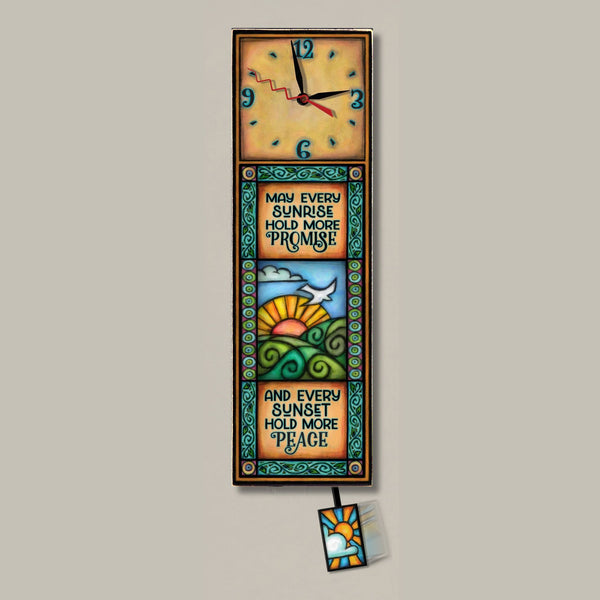 Sunrise Sunset wood wall clock, a tall rectangular art clock with a sunrise, hills, and bird design, featuring an inspirational quote border