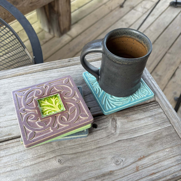 Handmade plum ceramic tree coaster with crazed glass center styled with a mug on a matching ceramic coaster by Macone Clay
