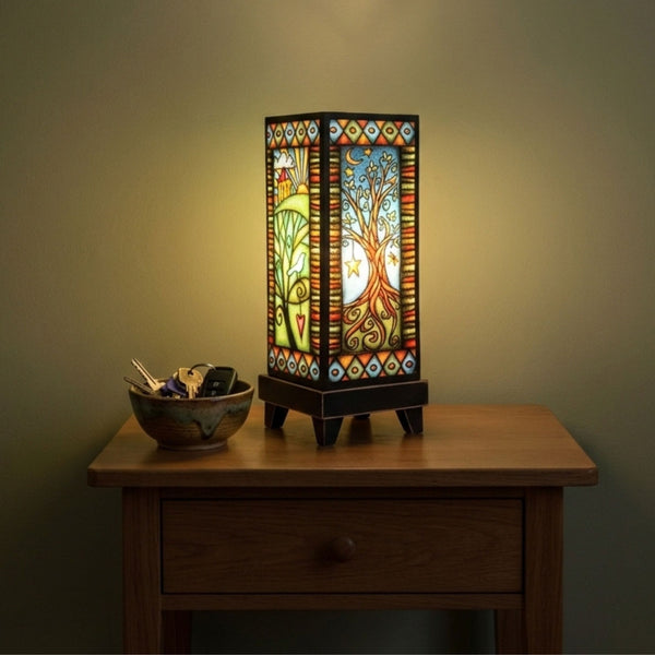 Tree Home mood lamp glowing on a bedroom nightstand