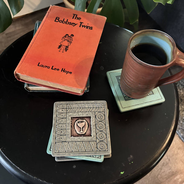 Handmade gray ceramic wine glass coaster with crazed glass center styled with a mug on a matching ceramic coaster by Macone Clay
