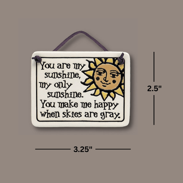 Dimensions view of Spooner Creek “You are my sunshine” Mini Charmer ceramic tile, measuring approximately 2.25 x 3.5 inches, ready to hang with leather like cord.
