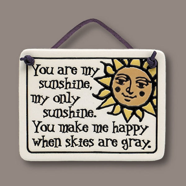 Handmade Spooner Creek Mini Charmer ceramic gift tile with “You are my sunshine” quote, featuring a smiling sun design and leather like cord, made in the USA.