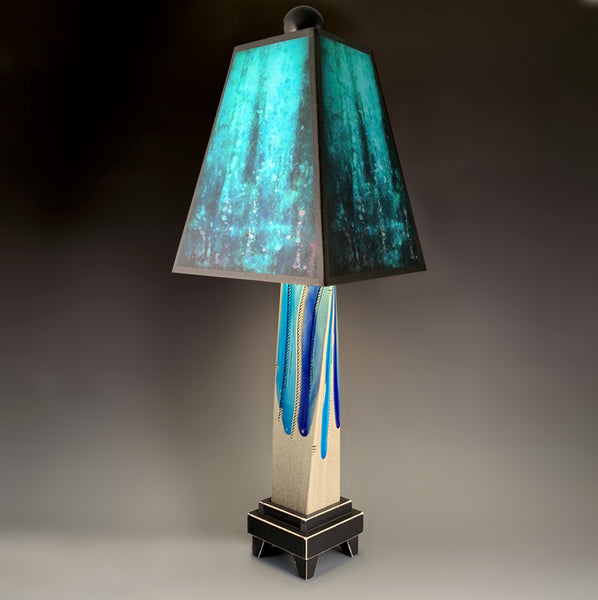 Blue Rain handmade ceramic table lamp with twisted gray extruded clay base, glowing deep blue layered shade by Macone Clay, made in Shell Lake Wisconsin