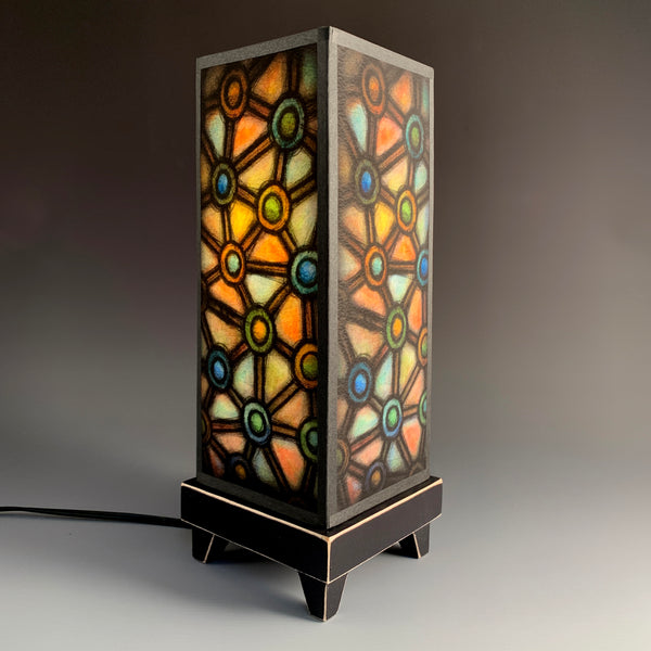 Connected Circles mood lamp lit and glowing with stained-glass style paper shade