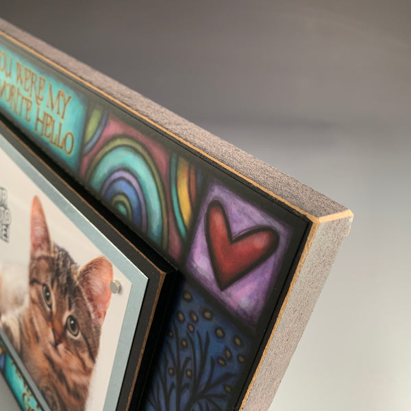 Corner detail of pet memorial picture frame artwork featuring paw prints and colorful Michael Macone illustration around the quote favorite hello hardest goodbye.
