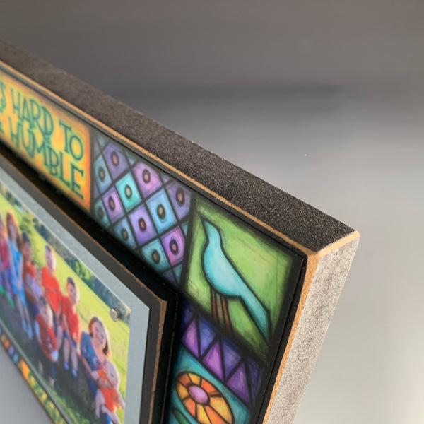 Corner detail of grandkids picture frame artwork showing colorful Michael Macone illustration surrounding the quote It’s hard to be humble when you have grandkids.