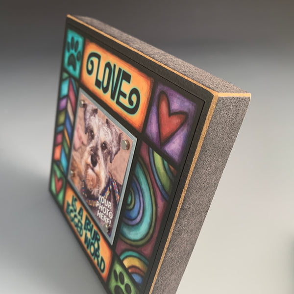 Close up of dog lover picture frame with Love is a four legged word quote and vibrant artwork, small photo display, gift for dog or pet owners