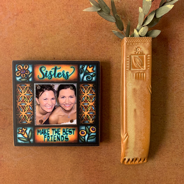 Sisters Make the Best Friends picture frame hanging on wall with Michael Macone artwork, small square wood frame with warm floral design, handmade in Shell Lake Wisconsin