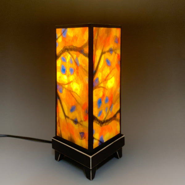 Stained Tree mood lamp lit with room lights off, showing warm golden glow