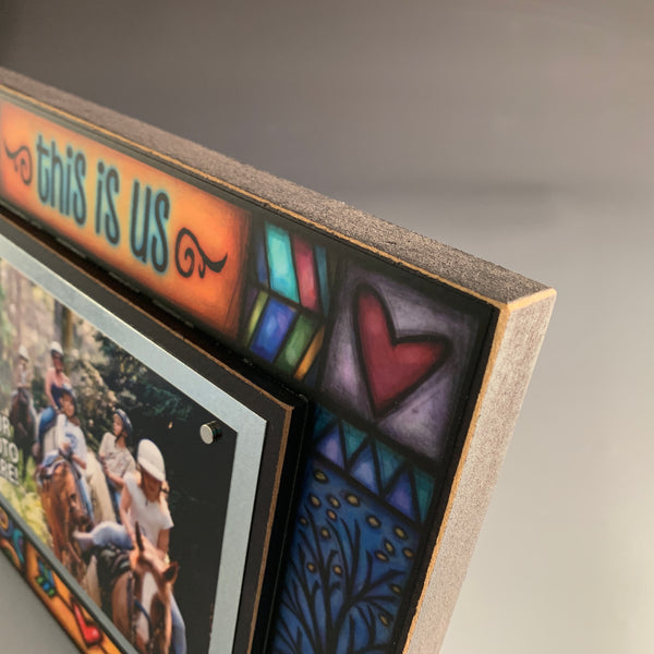 Side angle close up of This Is Us 8x10 wood picture frame showing stained glass style artwork layered edge and magnetic photo mount detail