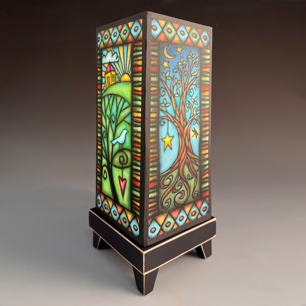 Tree Home mood lamp glowing with whimsical stained-glass paper shade