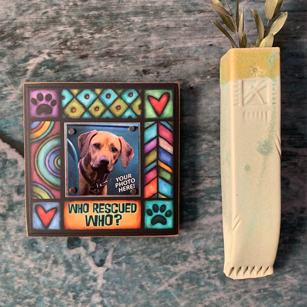 Who rescued who pet picture frame wall display featuring Michael Macone dog artwork with hearts and paw prints surrounding small square pet photo
